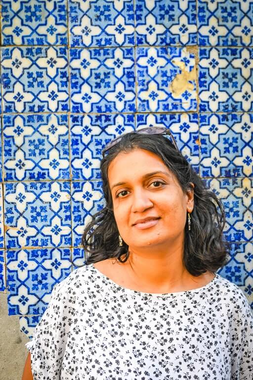 Author standing in front of a Porto building with azulejo tiles