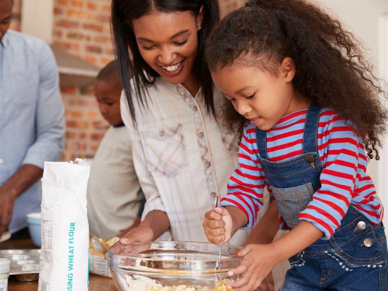 Mom and daughter baking a cake together