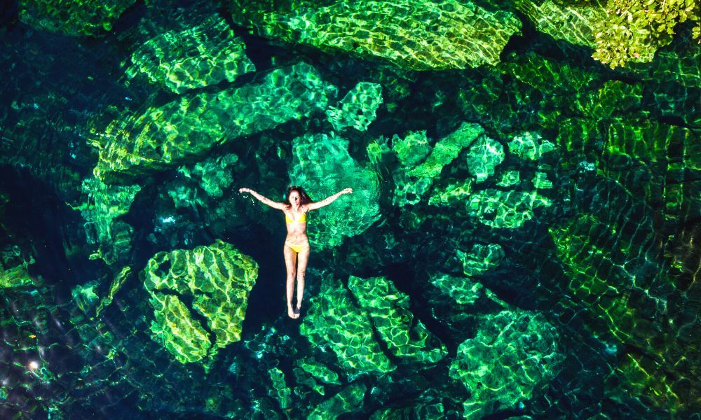 Woman floating in a cenote in the Yucatan Peninsula in Mexico
