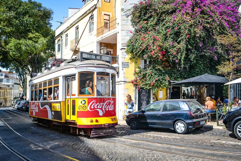 A quintessential street in Alfama Lisbon with a yellow tram